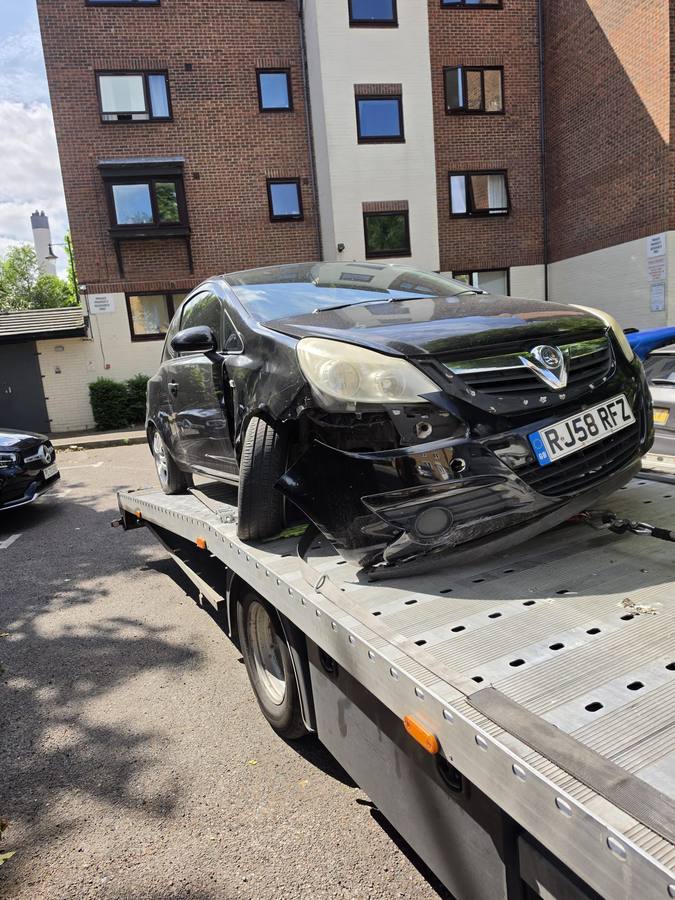 Black Opel Vauxhall car with front damage on recovery flatbed