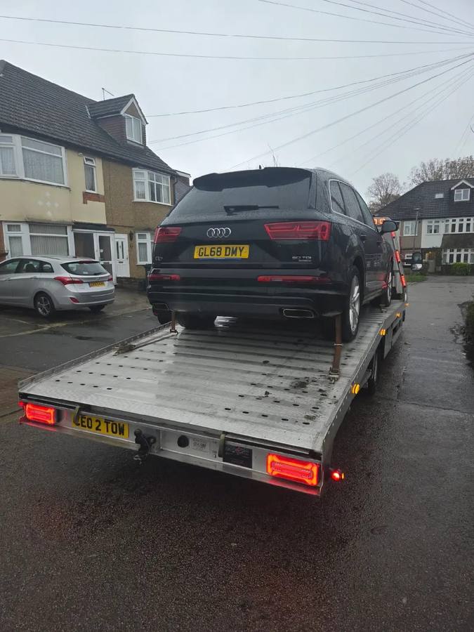Black Audi Q5 SUV transported on recovery truck